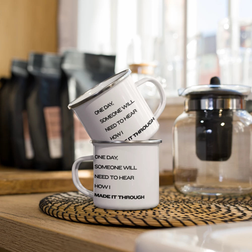 White enamel camping mug with a silver rim featuring the quote "How I Made It Through" in bold black typography.