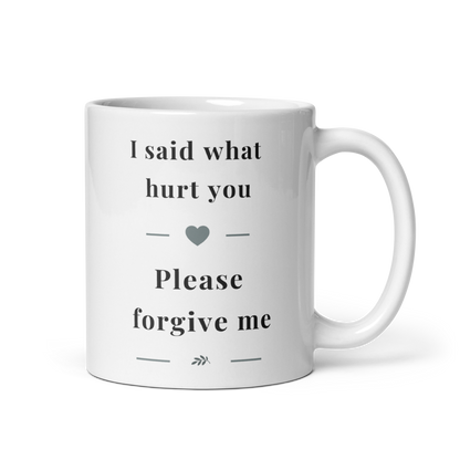 Side view of a white glossy ceramic mug with a comfortable C-handle, showing the "I said what hurt you" message in soft grey serif typography